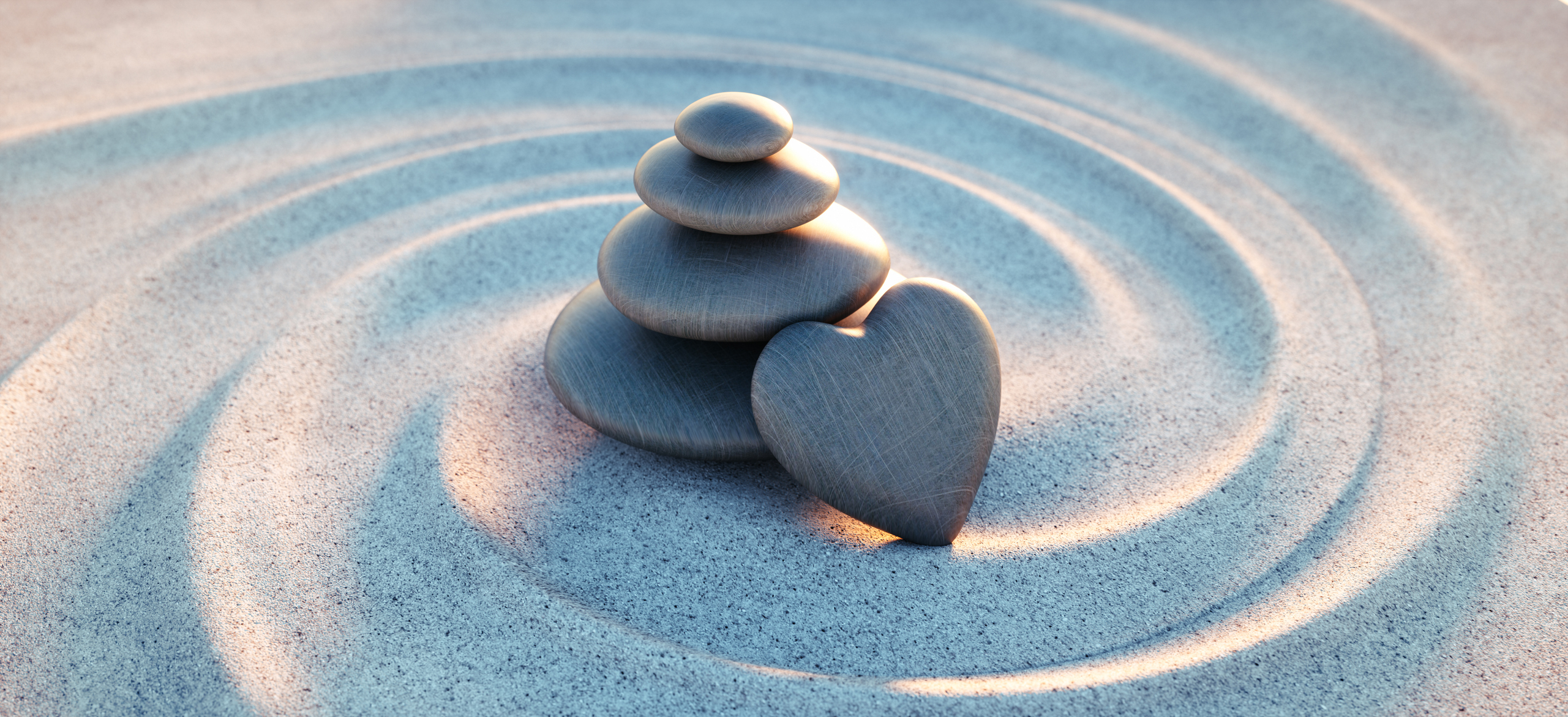 Galets empilés avec caillou en forme de coeur et vagues de sable en spirale